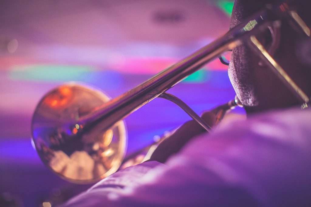 crop faceless male trumpeter performing jazz in concert