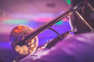 crop faceless male trumpeter performing jazz in concert